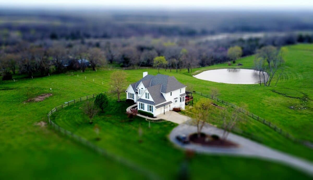 Aerial view of a country estate home with green pasture and pond, representing generational wealth and estate planning