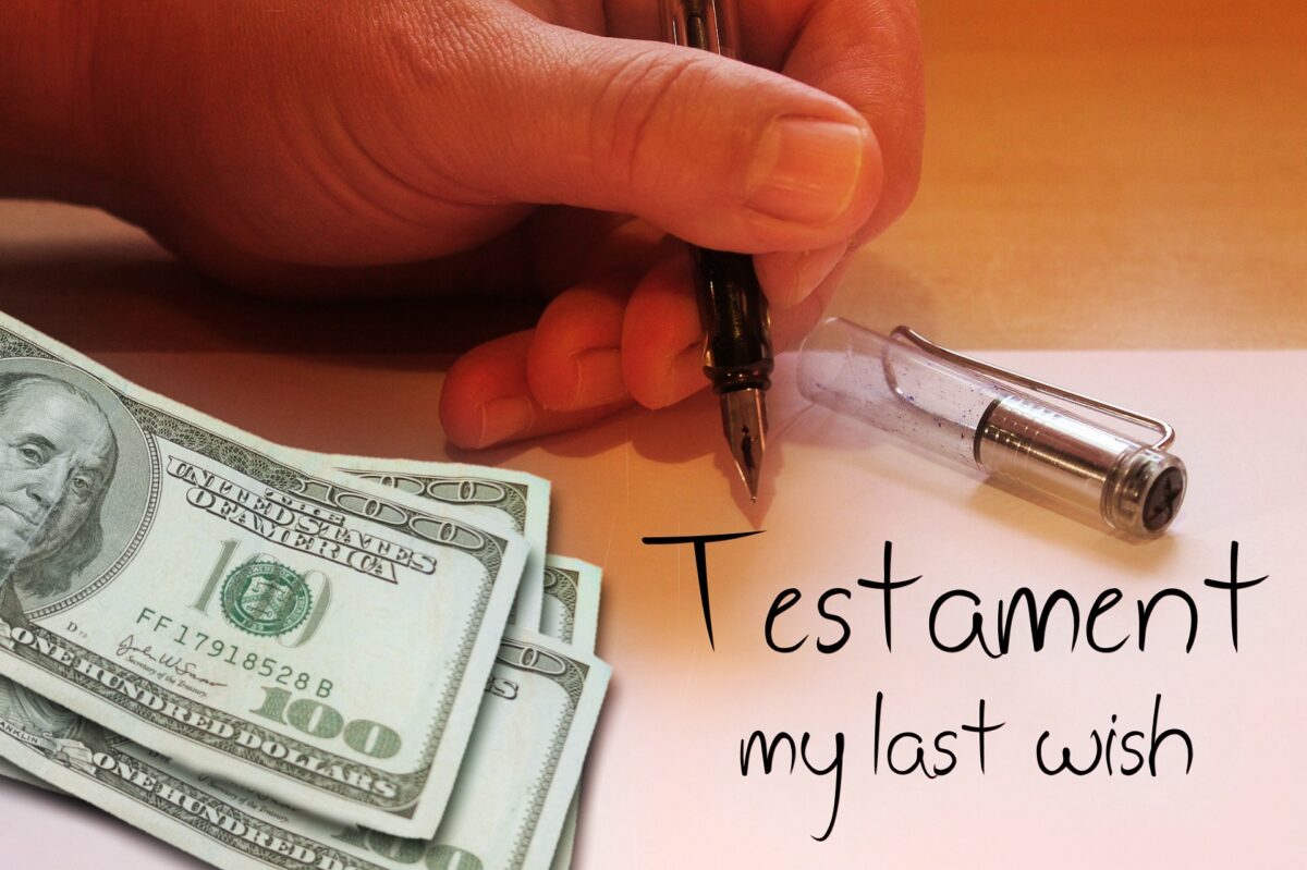 Hand signing a last will and testament with hundred-dollar bills – estate planning and asset transfer concept