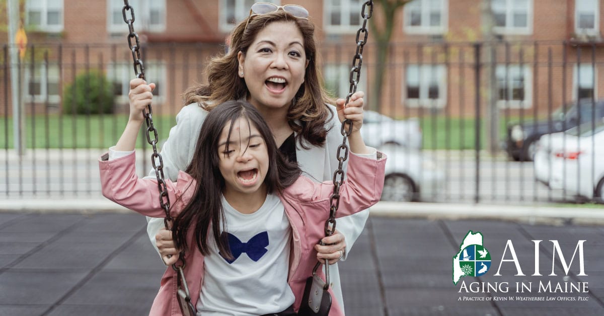Mother pushing her daughter on a swing while planning for the future through special needs estate planning in Maine.
