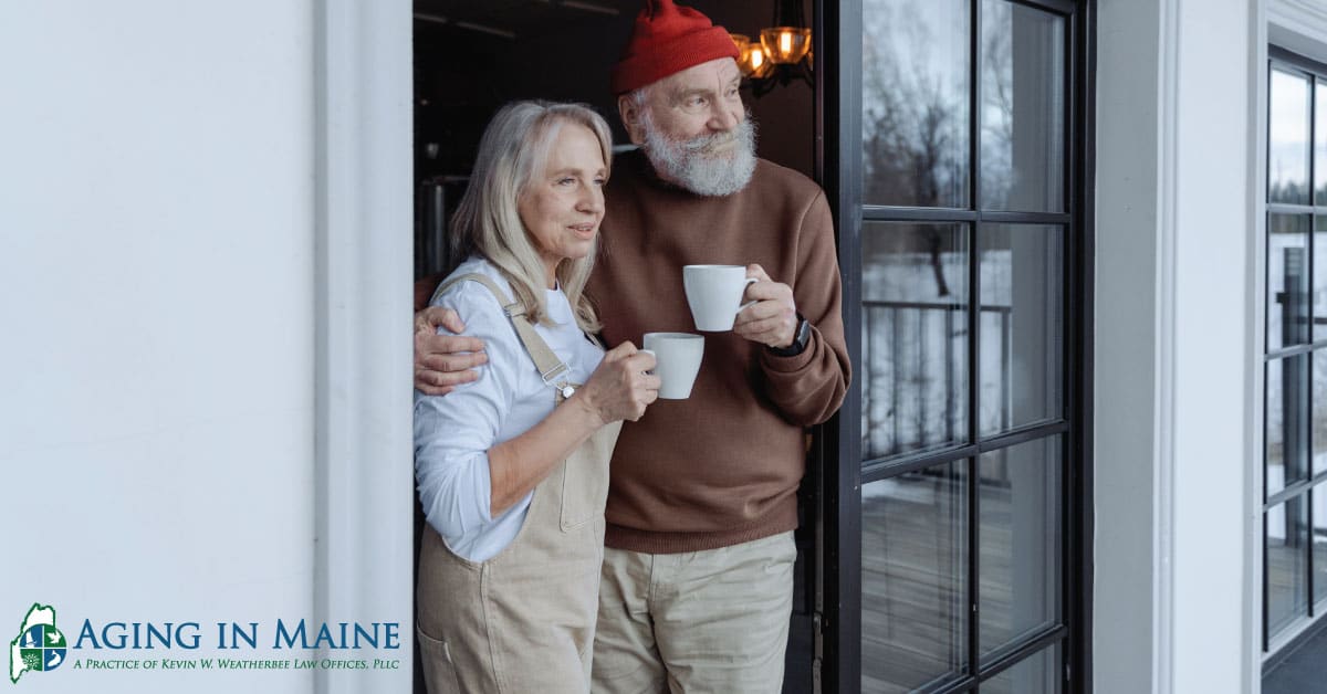 Older couple standing together at the doorway of their home